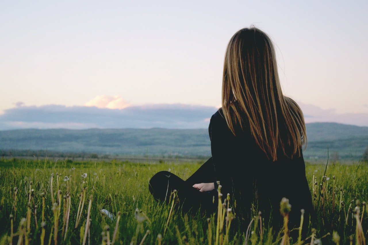 Jeune femme assise dans l'herbe