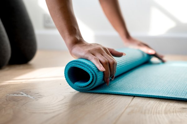 Femme roulant tapis de yoga